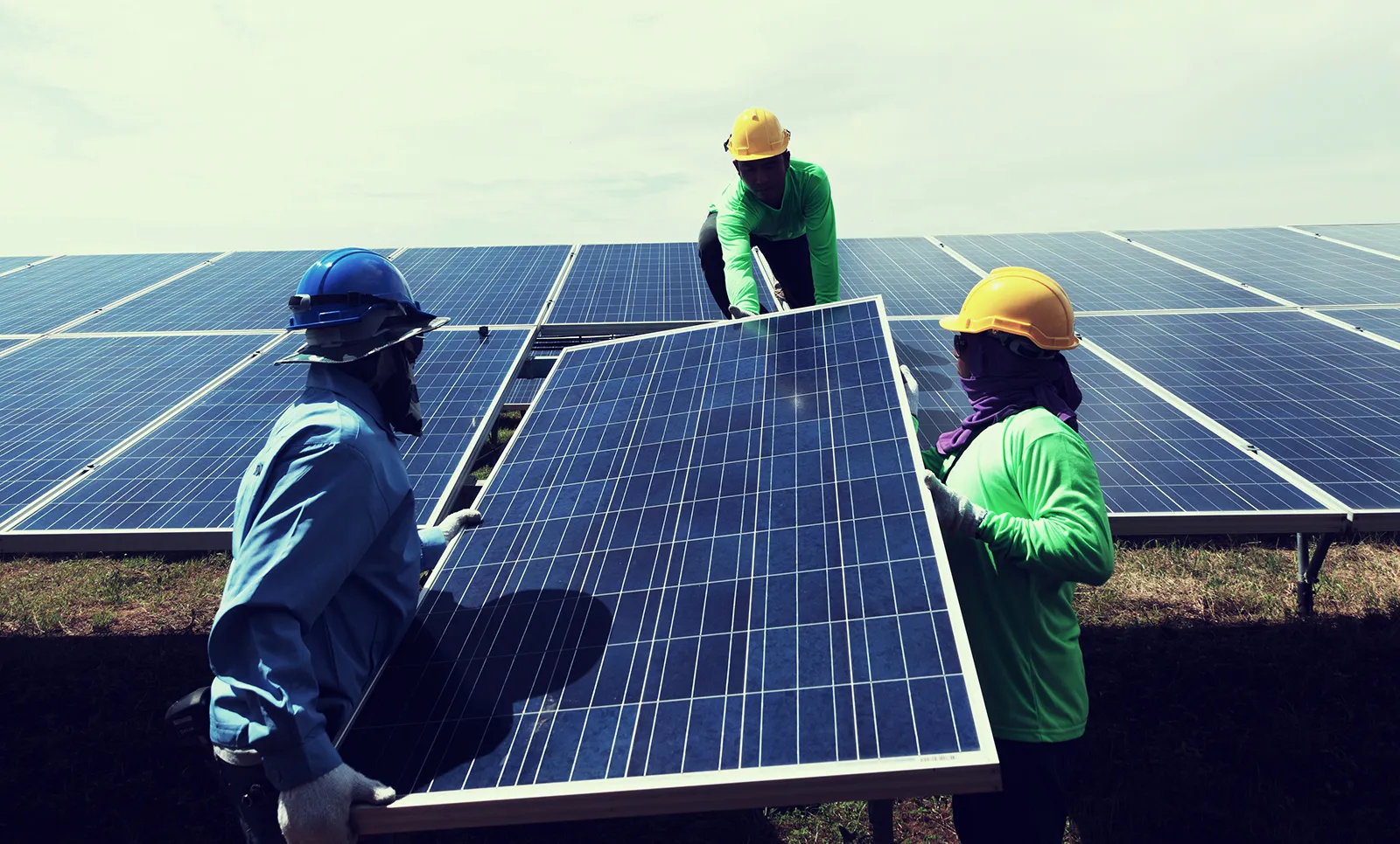 Engineers installing solar panels on a rooftop
