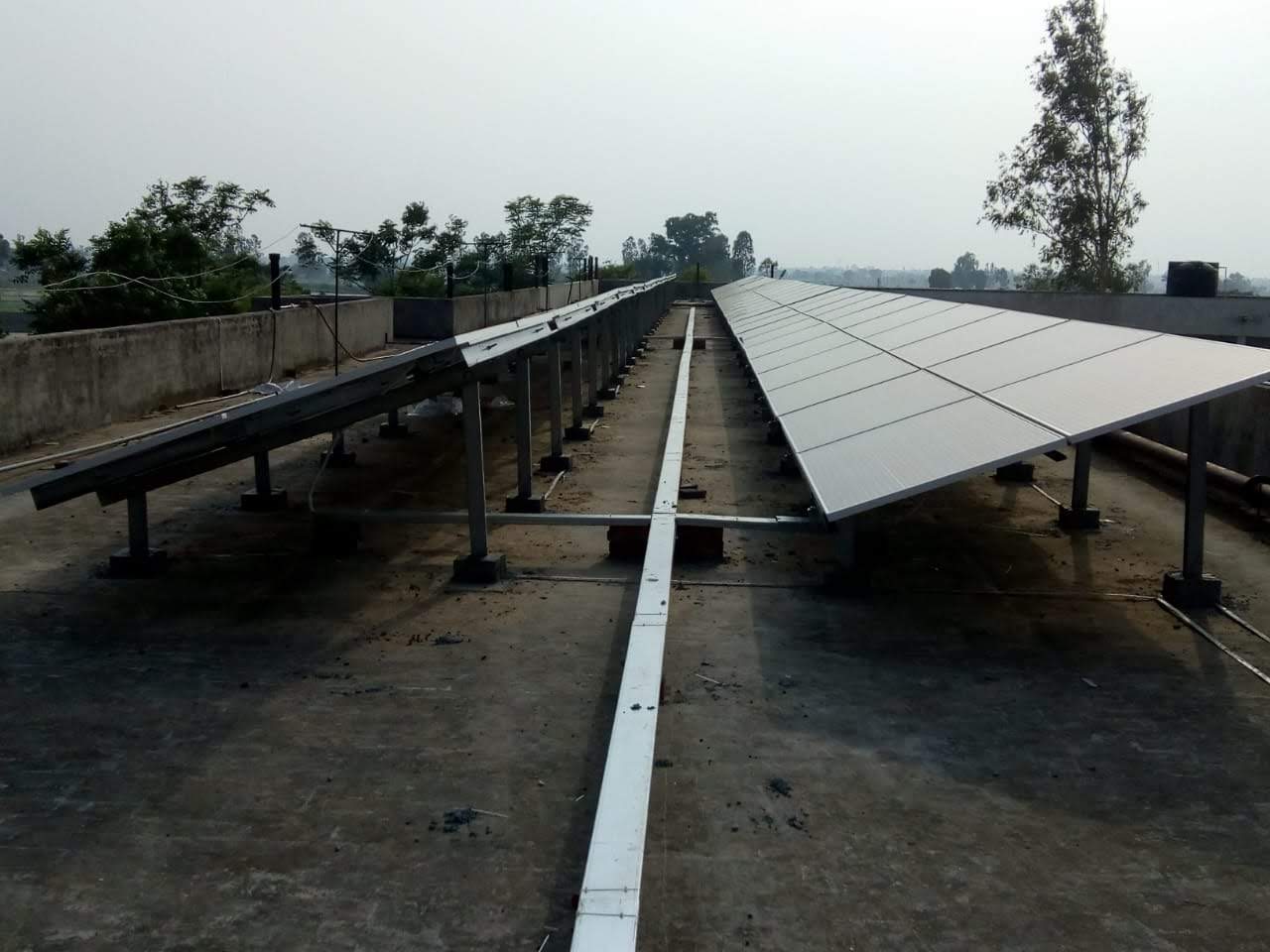 Rooftop solar panels on a home in Dehradun, surrounded by trees