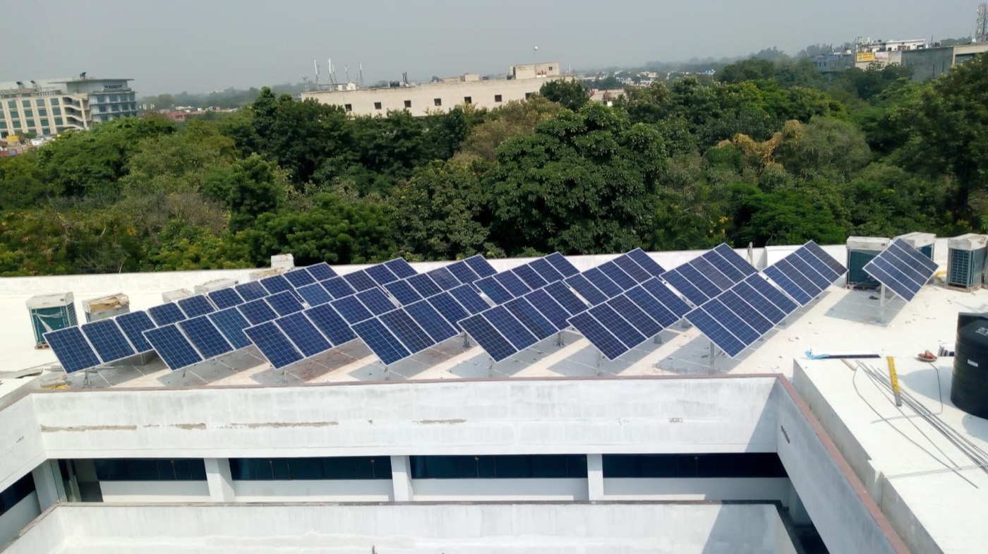 Rows of solar panels on the roof of a housing society block in Panchkula