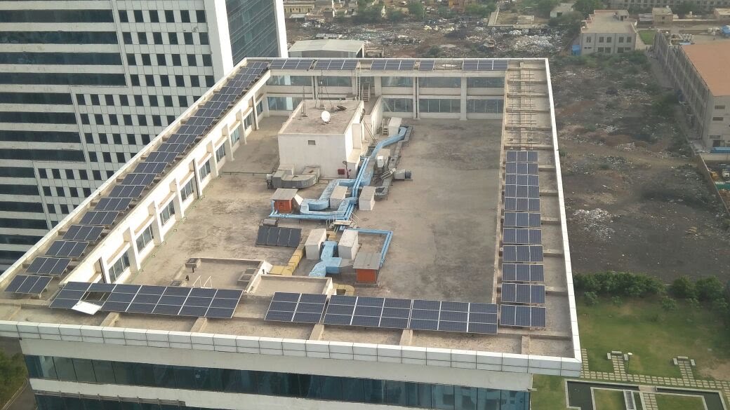 Aerial view of solar panels along the roof of a commercial tower